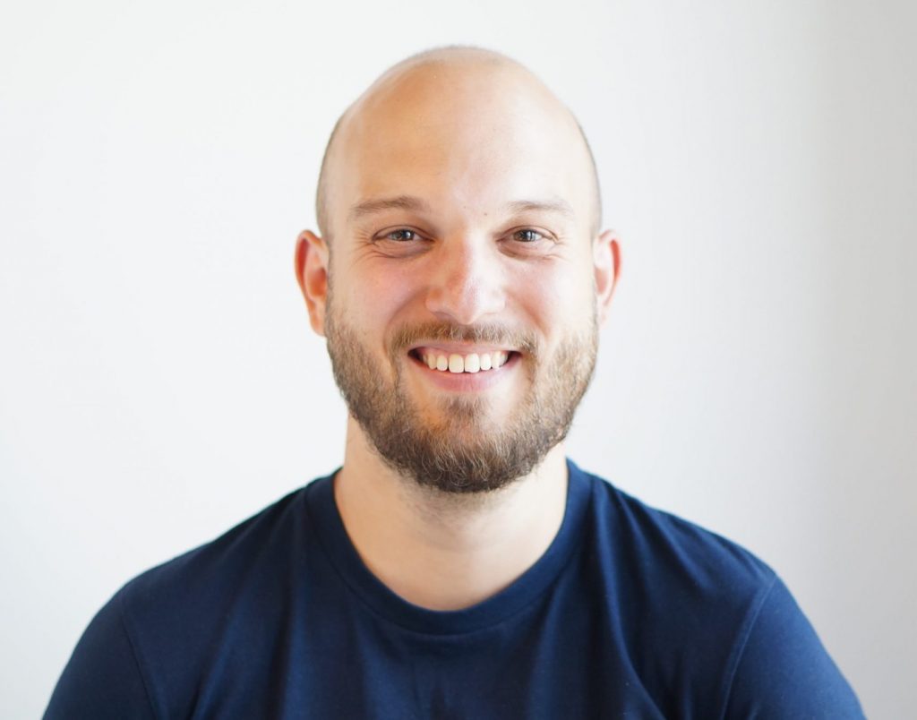 Lucas Dohmen schaut lächelnd in die Kamera.